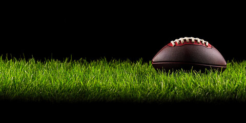 Obraz premium A classic football rests on vibrant green grass, symbolizing the anticipation of the game.
