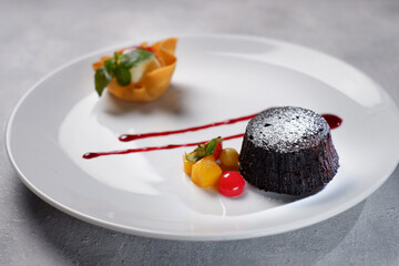 Chocolate cake, vanilla icecream, strawberry and baked apple chips. Flowers and green leaves as decoration 01