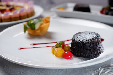 Chocolate cake, vanilla icecream, strawberry and baked apple chips. Flowers and green leaves as decoration 04
