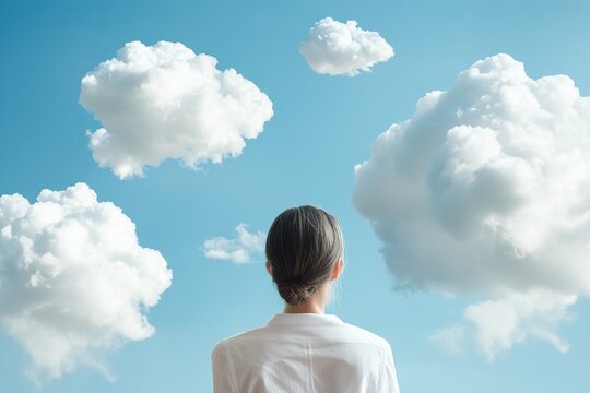 Looking up at fluffy clouds in a clear blue sky while embracing a moment of reflection and tranquility