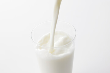 白い背景とグラスに注いだ牛乳　Milk poured into a glass with a white background