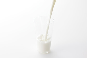 白い背景とグラスに注いだ牛乳　Milk poured into a glass with a white background