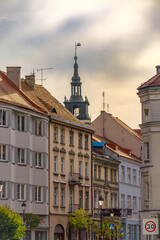 Obraz premium urban architecture in a big city. urban landscape in the morning, view of tenement houses, town hall tower with a clock. old historical buildings with decorations.