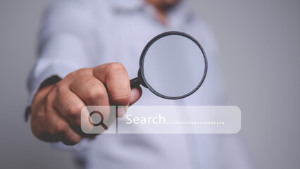 Man holding magnifying glass with search bar. Concept of research, discovery and searching for information, investigation, analysis and online searching.