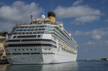 Gigantic cruiseship cruise ship liner Fascinosa docked at pier terminal in old town Valletta, Malta...