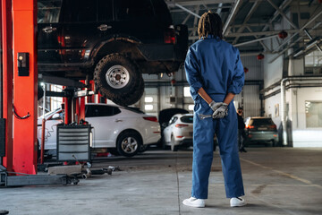 Tools in hands. Male mechanic is with car in garage