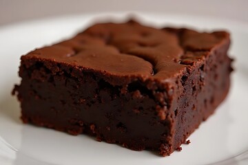 Close-up view of a chocolate brownie on a white plate.