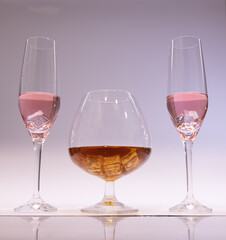 pink champagne and cognac glass with ice glasses up. White background