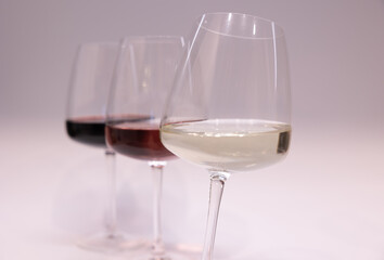 Red, white and rose wine glasses up. White background