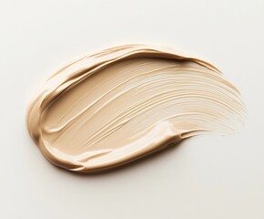 A close-up of a light beige liquid foundation texture, smoothly swiped across a clean white background. 