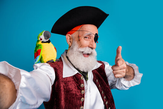 Photo portrait of senior funny pirate grandpa take selfie photo point you wear masquerade party costume isolated blue color background
