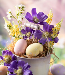 Easter eggs and flowers in a bucket with springtime background