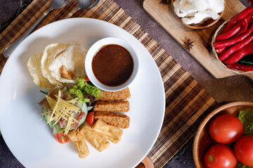 Gado-gado is a food consisting of vegetables, potatoes, tempeh, tofu, boiled eggs, etc. seasoned with peanut sauce and so on 1