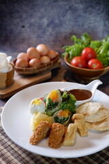 Gado-gado is a food consisting of vegetables, potatoes, tempeh, tofu, boiled eggs, etc. seasoned with peanut sauce and so on 4