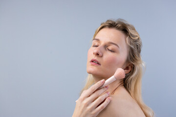 An Ethereal Portrait of a Woman Applying Makeup with a Blush Brush, Exuding Beauty and Confidence...