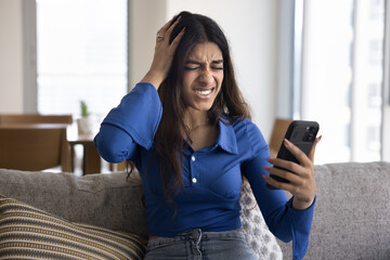Young Indian woman feels shocked, disappointed, received bad upsetting news in sms, rejection...