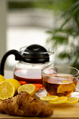 Glass cup of tea, teapot, sliced lemons on the table. Kettle with tea. Lemon tea