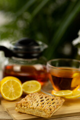 Glass cup of tea, teapot, sliced lemons on the table. Kettle with tea. Lemon tea