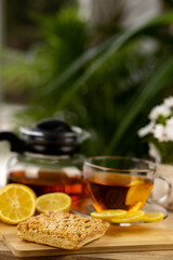 Glass cup of tea, teapot, sliced lemons on the table. Kettle with tea. Lemon tea