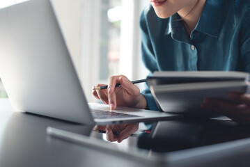 Female student studying, attending online class via laptop computer, doing research, e-learning. Business woman working on laptop computer, searching the ideas and taking note, business plan