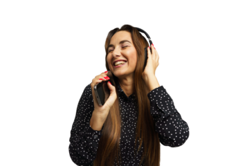 Woman happily enjoying music while wearing headphones and holding a smartphone