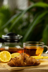 Glass cup of tea, teapot, sliced lemons on the table. Kettle with tea. Lemon tea