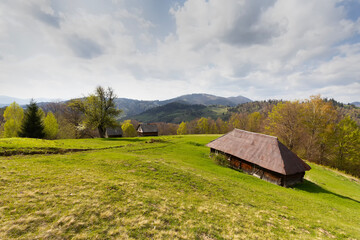Obraz premium An old wooden house in a mountain meadow. Carpathians