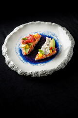 Elegant gourmet dish featuring beautifully arranged sushi with fresh ingredients, served on a textured plate. A vibrant and artistic presentation that emphasizes modern culinary trends.