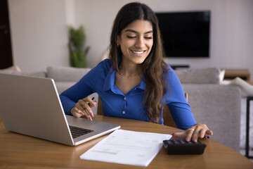 Woman sit at table with laptop, calculator, and paperwork, checking bank statement, make financial...