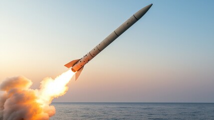 Obraz premium A missile launches into the sky over the ocean, showcasing powerful propulsion and advanced technology against a backdrop of a serene sunset.