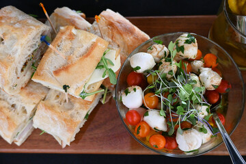 High angle view of a Charcuterie board with sandwiches and salad.
