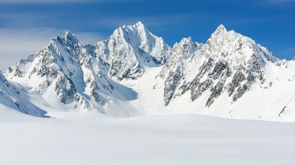 Majestic snow-capped mountains rise under a clear blue sky, showcasing jagged peaks and a serene white landscape.