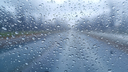 Obraz premium Windshield with moisture and water droplets with road in the background