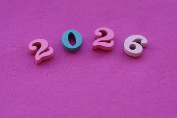 Una toma de cerca del numero dos mil veinte seis en un fondo fucsia 