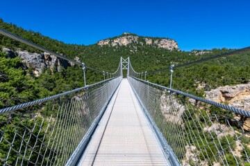 A suspension bridge crossing over a deep canyon with a powerful river below