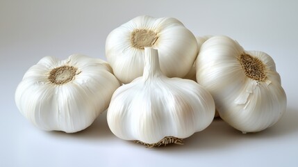 Obraz premium Fresh garlic bulbs arranged on a clean white surface.