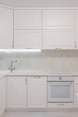 Facade of white kitchen furniture in the kitchen