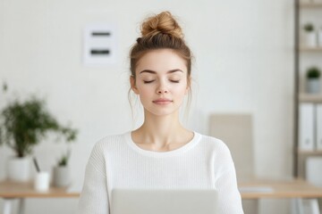 Naklejka premium portrait of young woman in minimalist home office practicing meditation at her desk before starting work