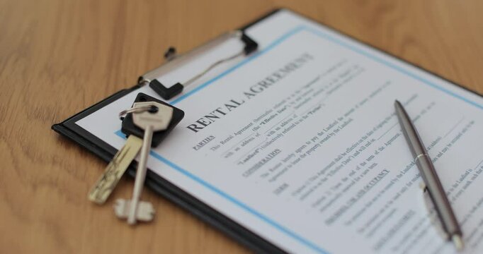 Close-up view of a rental agreement document with key, and a pen placed on top. Property rental, leasing contracts, real estate.