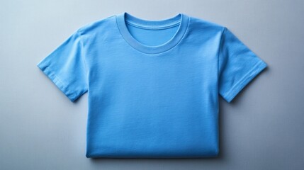 Folded light blue t-shirt on gray surface