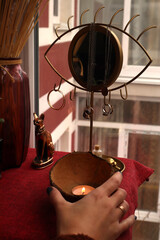 Candle in a woman's hand on a dressing table