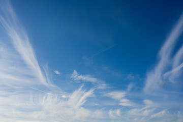 white cirrus clouds around the edge of the image with blue sky in the center