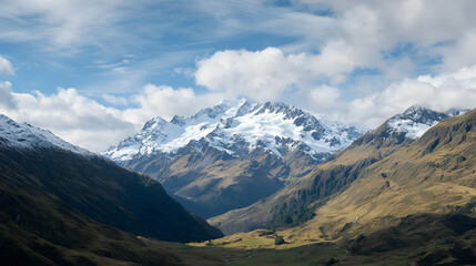 Snow Capped Mountain Peaks Surrounded By Lush Green Valley Under Cloudy Blue Sky