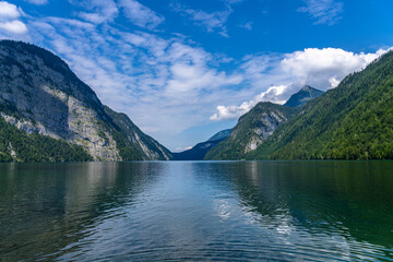 Beautiful panorama view of Konigssee Lake with Bavarian alps in background in Berchtesgaden national park on a sunny summer day with blue sky and cloud, Schoenau, Bavaria, Germany