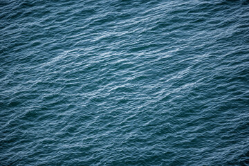 Blaue Wasseroberfläche als Hintergrund mit leichten Wellen