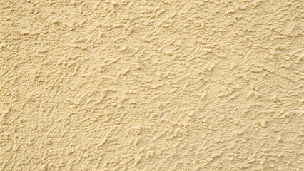 Textured Wall Surface: A close-up shot of a textured wall, the surface exhibiting a rough, stucco-like pattern in a warm beige hue, perfect for backgrounds.