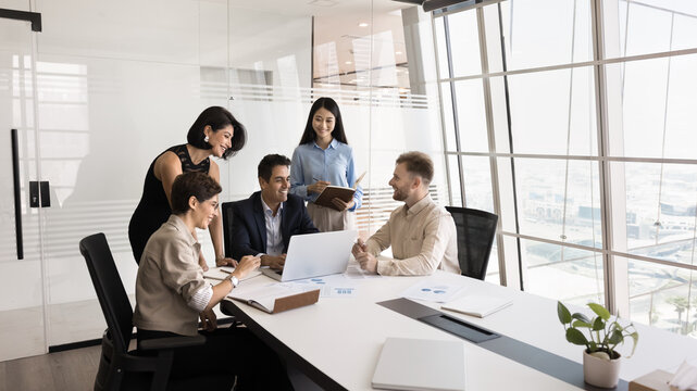 Effective project management. Creative multicultural group of diverse age businesspeople teammates coworkers lead by mature male ceo boss collaborate on startup develop new solution using notebook pc