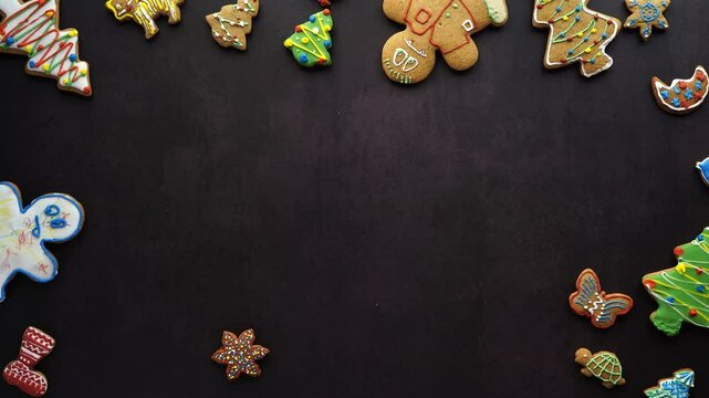 Photographer picking up colorful gingerbread cookies from a dark background