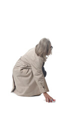 side view of a woman picking up a cigarette pack on the floor on white background