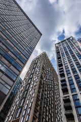 Fototapeta premium Modern Skyscrapers in London with Glass Facades and Dramatic Upward Perspective